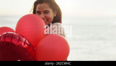 Liebe dich zuerst, bevor du jemanden anderen liebst. Kurzer Schuss einer schönen jungen Frau mit einem Haufen Ballons. Stockfoto