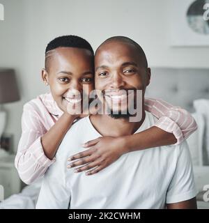 Die warme Umarmung eines glücklichen Zuhauses. Porträt eines liebevollen jungen Paares, das einen liebevollen Moment im Schlafzimmer zu Hause teilt. Stockfoto