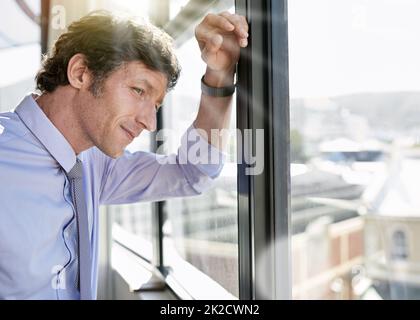 Erwägen, seine nächste Karriere zu bewegen. Aufnahme eines ehrgeizigen Geschäftsmannes, der durch sein Bürofenster schaut. Stockfoto