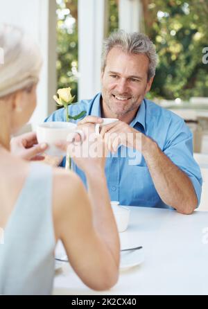 Es ist immer noch so schön, auch nach all den Jahren. Glückliches reifes Paar genießt eine Tasse Kaffee im Freien. Stockfoto