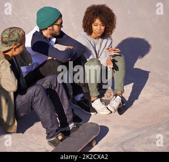 Technik durchgehen. Aufnahme einer Gruppe von Freunden, die in einem Skatepark herumhängen. Stockfoto