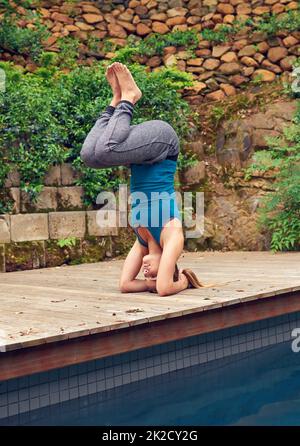 Ihr Körper und Geist stark zu halten. Ganzkörperaufnahme einer jungen Frau, die Yoga praktiziert. Stockfoto