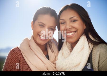 Unsere Freundschaft ist auf Dauer aufgebaut. Zwei junge Frauen lächeln fröhlich vor der Kamera. Stockfoto