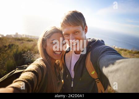 Teilen Sie die Natur. Porträt eines glücklichen jungen Paares auf einer Wanderung. Stockfoto