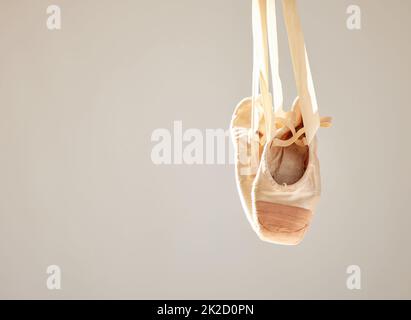 Ballett ist nur gut, wenn es großartig ist. Aufnahme eines Paares auf Ballettschuhen, die in einem Tanzstudio hängen. Stockfoto