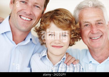 Familienbande. Zugeschnittenes Porträt eines Jungen, der mit seinem Vater und Großvater steht. Stockfoto