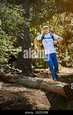 Die Natur auf der Flucht genießen. Aufnahme eines jungen Mannes, der auf einem Naturlehrpfad läuft. Stockfoto