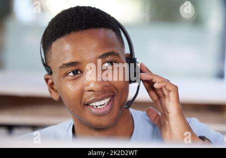 Er hält eine außergewöhnliche Art und Weise am Telefon. Aufnahme eines jungen Geschäftsmannes, der in einem Callcenter arbeitet. Stockfoto