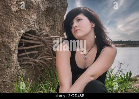 EMO Gothic Punk Girl Frauen, die am See sitzen Stockfoto