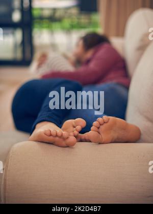 Gemeinsam besser. Ein junges Paar, das auf dem Sofa zusammenklatscht. Stockfoto