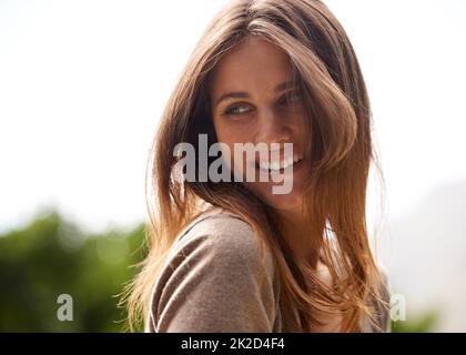 Sorglos und positiv. Aufnahme einer Frau, die die Sonne im Freien genießt. Stockfoto