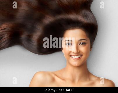 Haarpflege. Studioaufnahme einer schönen jungen Frau mit langen braunen Haaren. Stockfoto