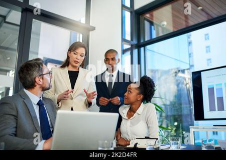 Die Arbeit mit Teamarbeit erledigen. Eine Aufnahme einer Gruppe von Geschäftskollegen, die sich im Sitzungssaal treffen. Stockfoto