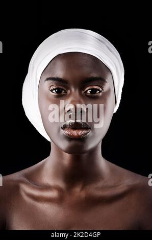 Mode ist eine stille Sprache. Studioporträt einer schönen Frau, die ein Kopftuch auf schwarzem Hintergrund trägt. Stockfoto