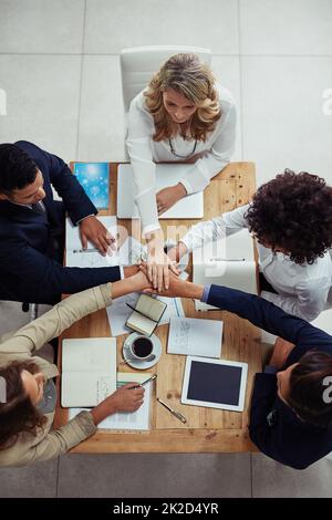 Lassen Sie uns es einen weiteren Sieg für das Team machen. Eine Aufnahme einer Gruppe von Geschäftsleuten, die sich in einer Einheit zusammengeschlossen haben. Stockfoto