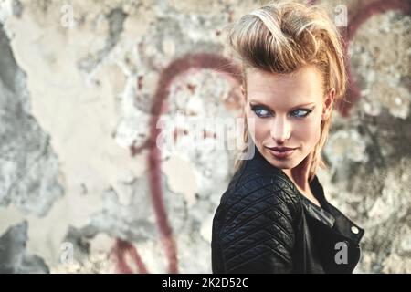 Es ist so Rock'n Roll. Kurzer Schuss einer jungen, kantigen Frau in einer städtischen Umgebung. Stockfoto