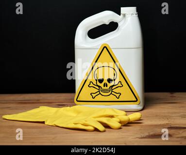 Sicherheit geht vor. Schuss einer Flasche giftiger Flüssigkeit und eines Handschuhs auf Schwarz isoliert. Stockfoto