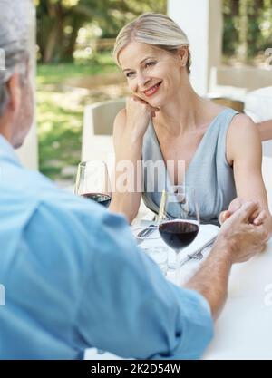 Hes ist immer noch ihr Traummann. Glückliches reifes Paar, das seine Liebe mit zwei Gläsern Wein im Freien toaste. Stockfoto