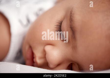 Der süßeste Schlaf eines Babys. Aufnahme eines entzückenden Jungen, der zu Hause friedlich auf dem Bett schläft. Stockfoto
