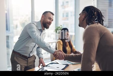 Wir haben ein Abkommen. Eine kurze Aufnahme von zwei gutaussehenden Geschäftsleuten, die sich tagsüber während eines Meetings im Büro die Hände schüttelten. Stockfoto