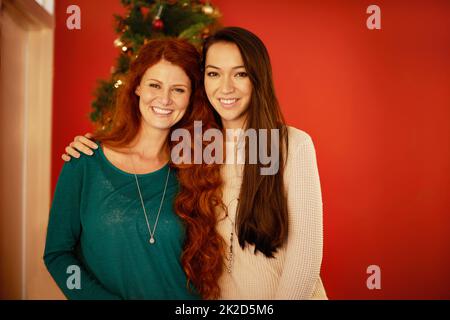 Die Liebe am Weihnachtstag teilen. Porträt zweier junger Freunde, die gemeinsam Weihnachten feiern. Stockfoto