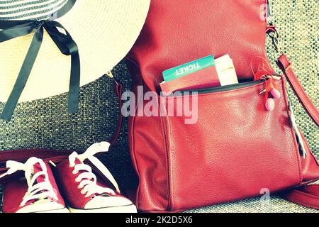 Damen Sommeroutfit: Rucksack, Hut, Turnschuhe. Reisehintergrund und touristisches Zeug Stockfoto