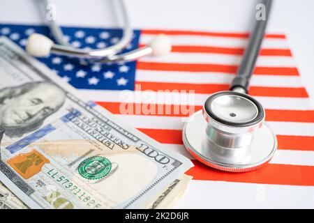 Schwarzes Stethoskop mit US-Dollar-Banknoten auf US-amerikanischer Flagge, Geschäfts- und Finanzkonzept. Stockfoto