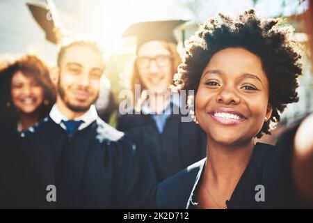 Bereit für neue Anfänge. Ausgeschnittene Aufnahme einer Gruppe von Studenten, die zusammen ein Selfie machen. Stockfoto