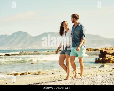 Wir teilen eine tiefe Liebe zum Strand. Aufnahme eines jungen Ehepaares, das am Strand läuft. Stockfoto