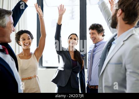 Go Team. Aufnahme einer Gruppe von begeisterten Geschäftsleuten, die sich gegenseitig eine hohe fünf gaben. Stockfoto