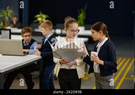 Der kleine Chef und die Sekretärin besprechen den Arbeitsplan Stockfoto