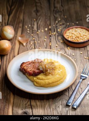 Tschechische Küche, geräuchertes Fleisch mit Erbsenbrei und gebratene Zwiebel bis golden Stockfoto