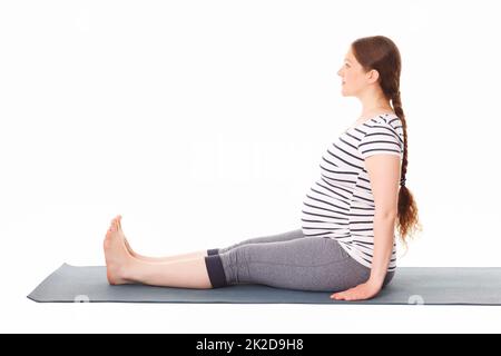 Schwangere, die Yoga Asana Dandasana macht Stockfoto
