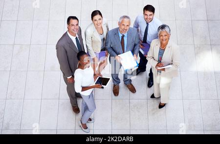 Sie sind ein dynamisches Team. Aufnahme einer Gruppe von Geschäftsleuten, die in einem Meeting über Papierkram diskutieren. Stockfoto