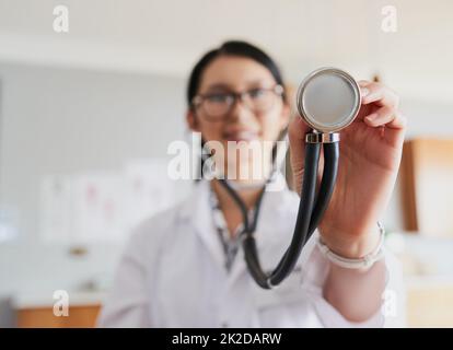 Zeit, Ihre Herzfrequenz zu überprüfen. Zugeschnittene Aufnahme einer jungen Ärztin, die mit einem Stethoskop ausstreckte, um Ihrem Herzschlag zuzuhören. Stockfoto