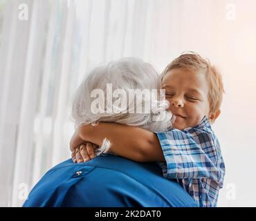 Ich liebe dich so sehr, Oma. Ausgeschnittene Aufnahme einer älteren Frau, die Zeit mit ihrem liebenden Enkel verbringt. Stockfoto