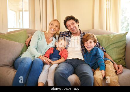 Eine Liebe teilen, die das Herz erwärmt. Porträt einer glücklichen Familie, die zu Hause viel Zeit miteinander verbringt. Stockfoto