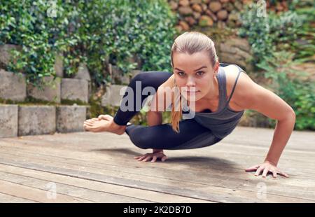 Starker Geist, starker Körper. Aufnahme einer jungen Frau, die im Freien Yoga praktiziert. Stockfoto