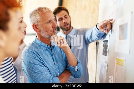 In Anbetracht ihrer Optionen. Aufnahme von Geschäftsleuten, die in einem Büro zusammenarbeiten. Stockfoto