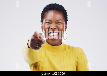 Du bist fantastisch, bleib am Leuchten. Porträt einer schönen jungen Frau, die vor grauem Hintergrund auf die Kamera zeigt. Stockfoto