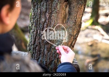 Verbindung zu Natur und Bäumen durch das Nabelschnurherz-Symbol Stockfoto