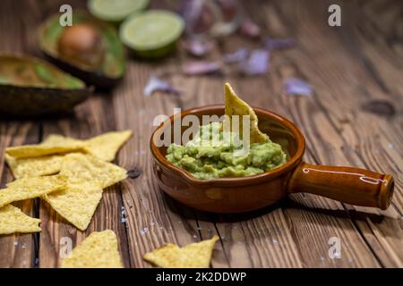 Avocado Dip mit Knoblauch, Chili, Pfeffer und Limettensaft mit Mais Nachos gewürzt Stockfoto