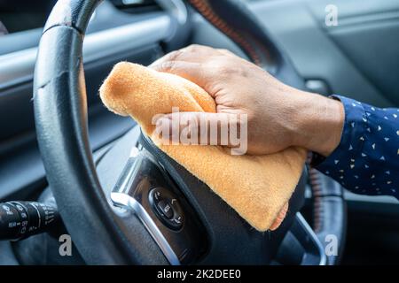 Neue normale, asiatische arbeitende Frau reinigen im Auto durch Druck blaues Alkohol Desinfektionsmittel Gel zum Schutz der Sicherheit Coronavirus. Stockfoto