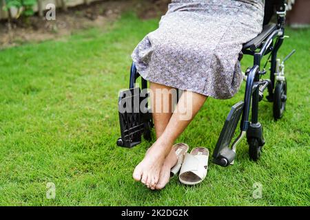 Asiatische ältere Frau Behinderung Patient sitzt auf Rollstuhl im Park, medizinisches Konzept. Stockfoto
