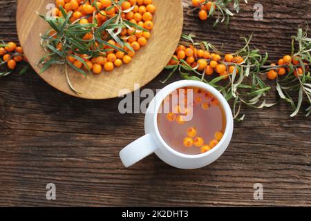 Tee Sanddorn Beeren mit Verzweigung auf dunklem Hintergrund Stockfoto