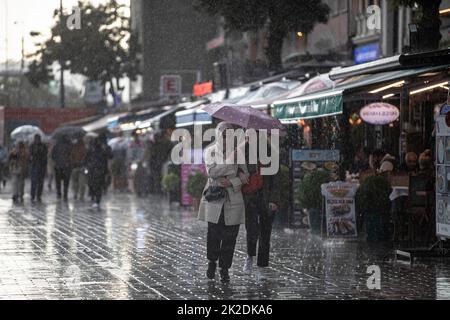 Istanbul, Türkei. 22. September 2022. Die Menschen sahen, wie sie bei einem Regen mit Sonnenschirmen um den Karakoy Kai wanderten. Der starke Regen, der in Istanbul wirksam war, hat das Leben um die Galata-Brücke und den Karakoy-Dock negativ beeinflusst. Kredit: SOPA Images Limited/Alamy Live Nachrichten Stockfoto