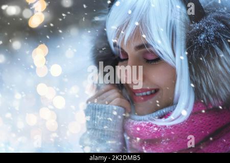 Junge Frau mit weißen Haaren läuft im verschneiten Winterwald Stockfoto