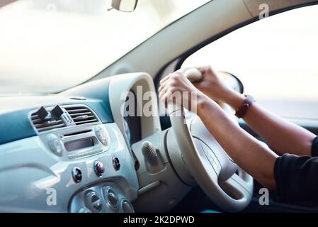 Shes bereit, die Straße zu treffen. Ausgeschnittene Aufnahme einer nicht erkennbaren Geschäftsfrau, die ihr Auto fährt. Stockfoto