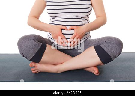 Schwangere, die Yoga Asana Asana Sukhasana macht Stockfoto