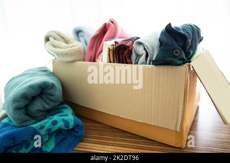 Spendenbox mit gebrauchter Kleidung zu Hause, um die Hilfe für arme Menschen in der Welt zu unterstützen. Stockfoto